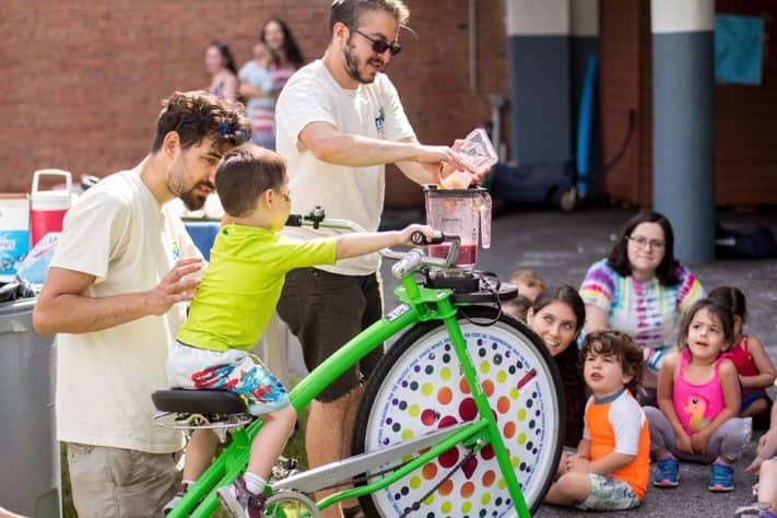 Itai Gal and Jacob Leeser help a student make a pedal-powered fruit smoothie | Emily Glick