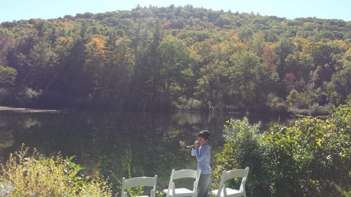 A young Camp Teva participant blows the shofar in front of Lake Miriam | Photo: Arielle Aronoff